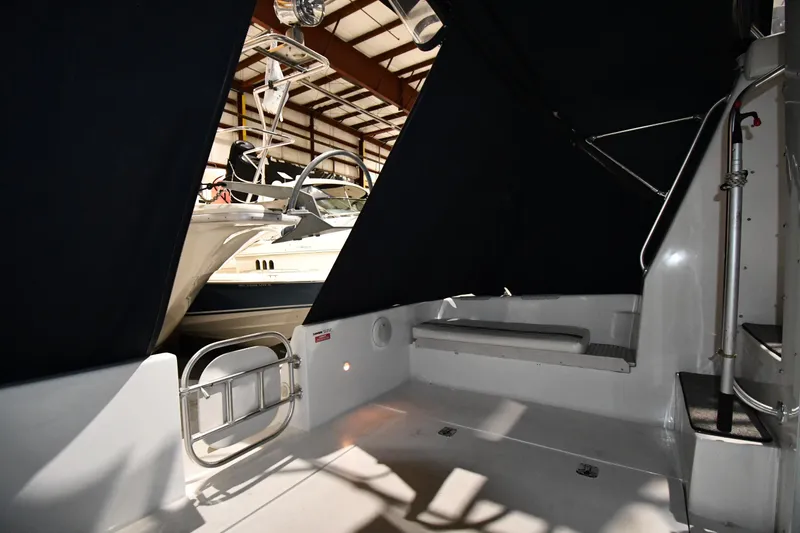 Slide: The Image of 1997 Mainship 40 Sedan Bridge interior with seating, docked in a covered marina. - 11