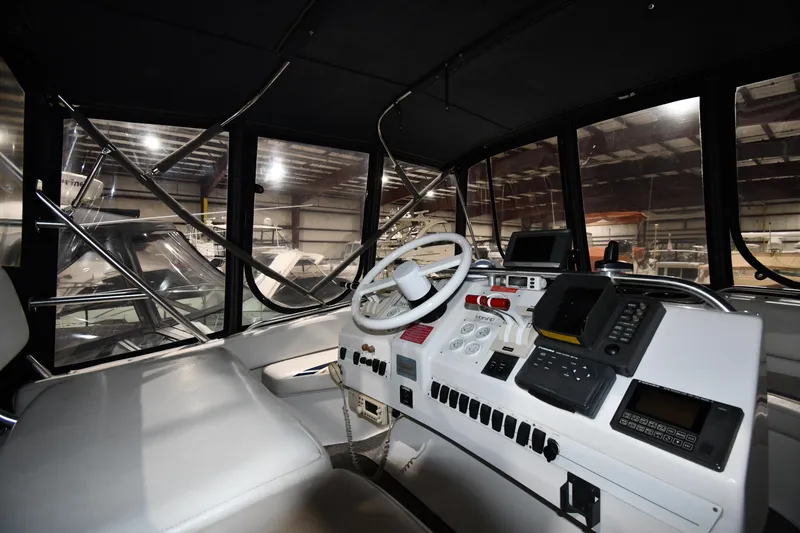 Slide: The Image of 1997 Mainship 40 Sedan Bridge helm with steering wheel and navigation equipment in a marina. - 15