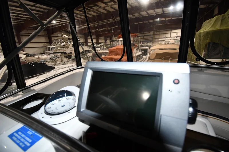 Slide: The Image of 1997 Mainship 40 Sedan Bridge interior with navigation equipment in a boat storage facility. - 18