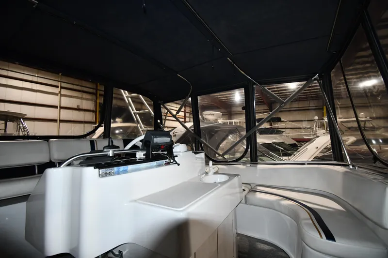 Slide: The Image of 1997 Mainship 40 Sedan Bridge interior with helm and seating area in a boatyard. - 19