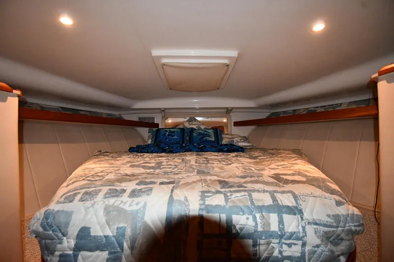 Slide: The Image of 1997 Mainship 40 Sedan Bridge cabin interior with cozy bed and ambient lighting. - 23