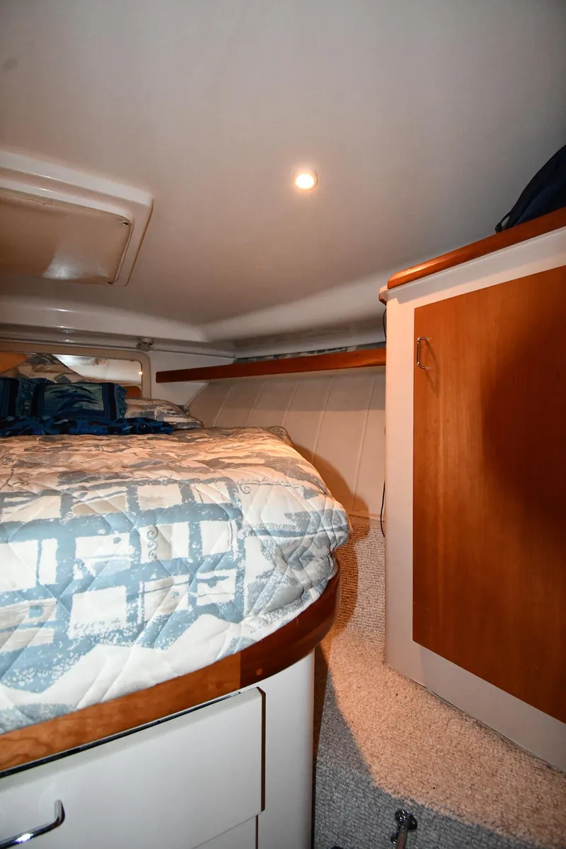 Slide: The Image of 1997 Mainship 40 Sedan Bridge cabin interior with bed and wooden storage. - 24