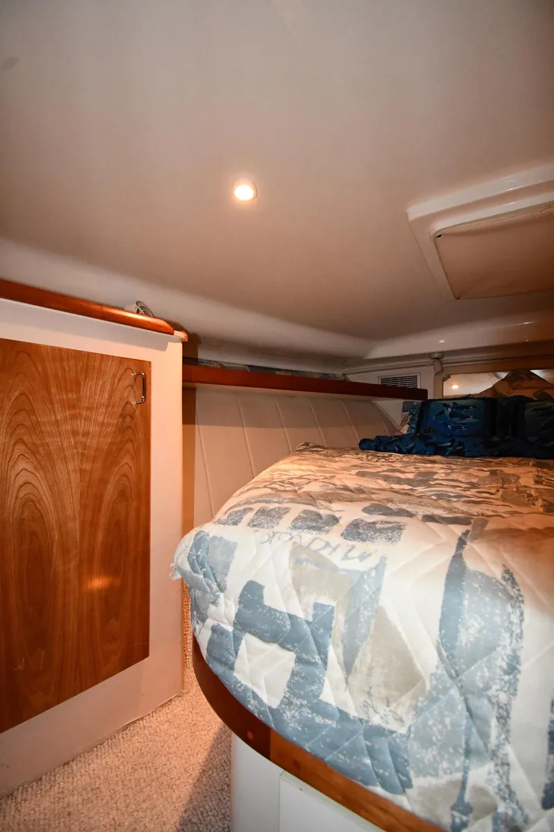 Slide: The Image of 1997 Mainship 40 Sedan Bridge cabin interior with bed and wooden accents. - 25