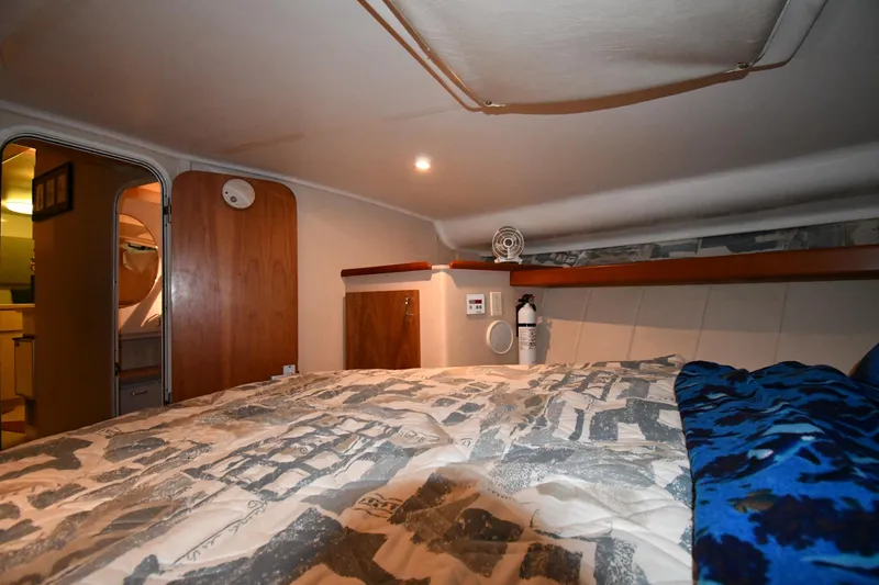Slide: The Image of 1997 Mainship 40 Sedan Bridge cabin interior with cozy bed and wooden accents. - 26