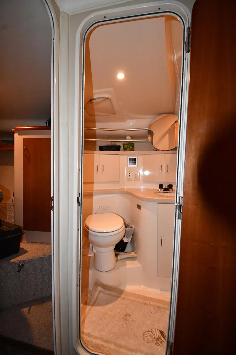 Slide: The Image of 1997 Mainship 40 Sedan Bridge bathroom with toilet, sink, and storage cabinets. - 29