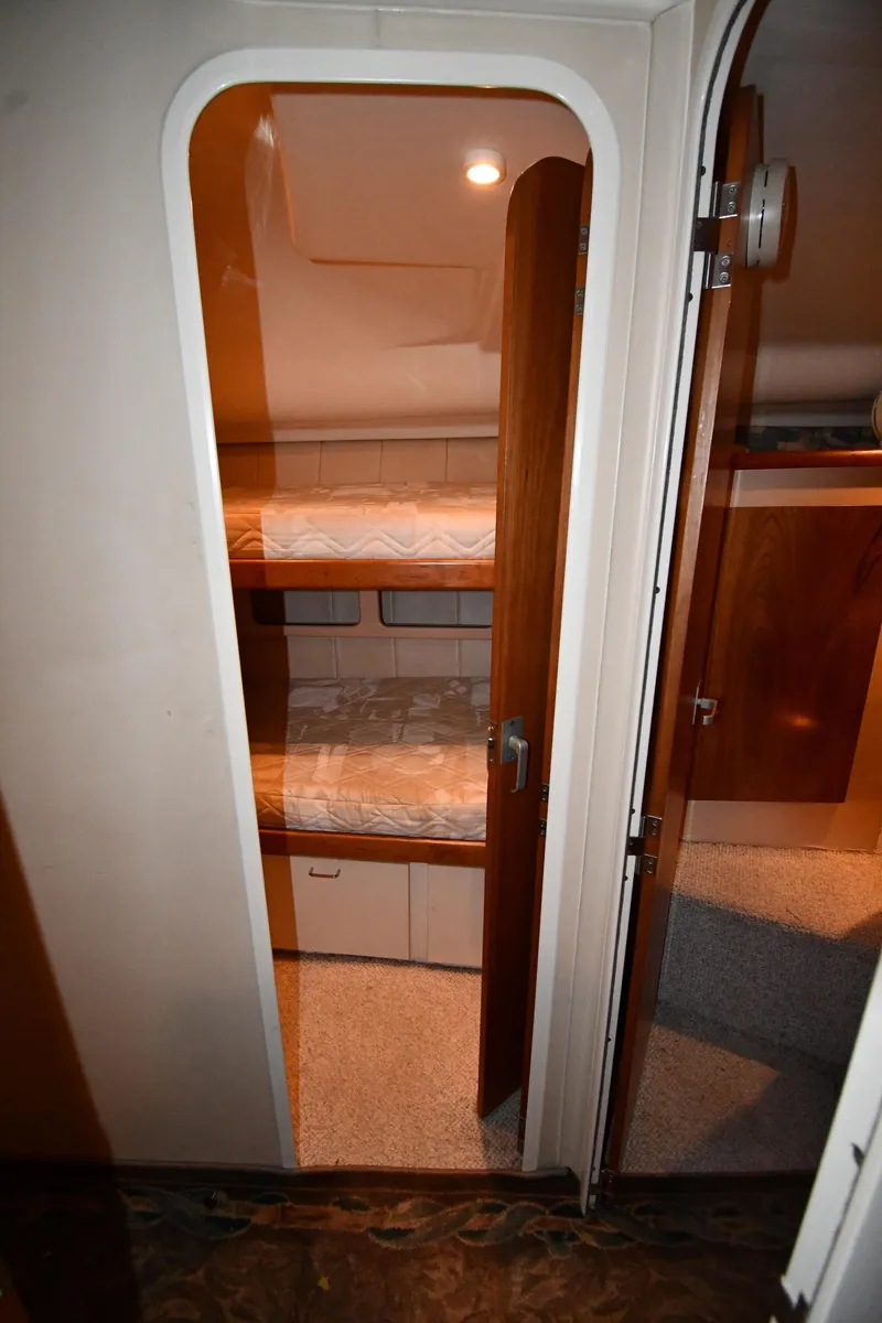 Slide: The Image of 1997 Mainship 40 Sedan Bridge interior with bunk beds and wooden cabinetry. - 32