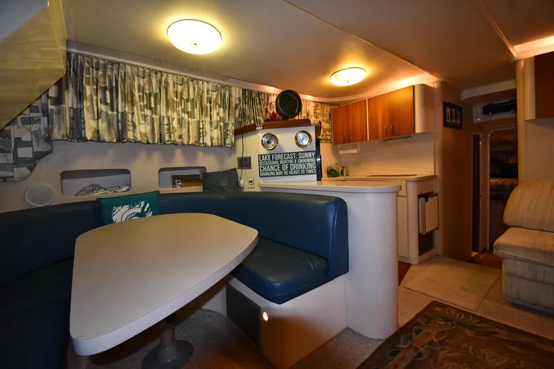 Slide: The Image of 1997 Mainship 40 Sedan Bridge interior with dining area, kitchenette, and cozy seating. - 37