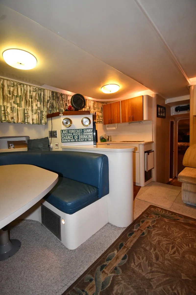 Slide: The Image of 1997 Mainship 40 Sedan Bridge interior with dining area, kitchen, and cozy seating. - 38