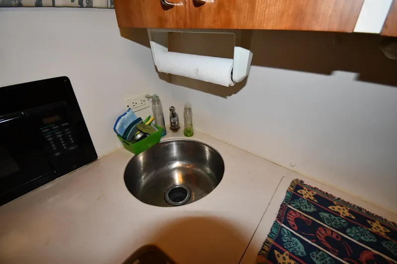 Slide: The Image of 1997 Mainship 40 Sedan Bridge kitchen sink area with countertop and microwave. - 42