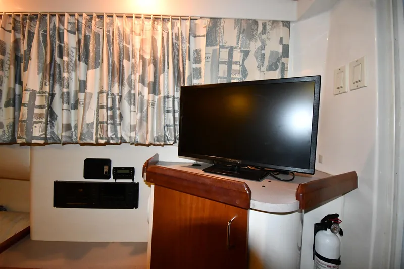 Slide: The Image of Interior of 1997 Mainship 40 Sedan Bridge with TV, curtains, and fire extinguisher. - 46