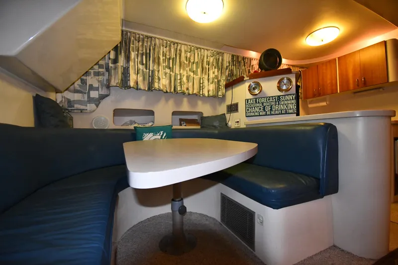 Slide: The Image of 1997 Mainship 40 Sedan Bridge interior with cozy dining area and blue seating. - 48