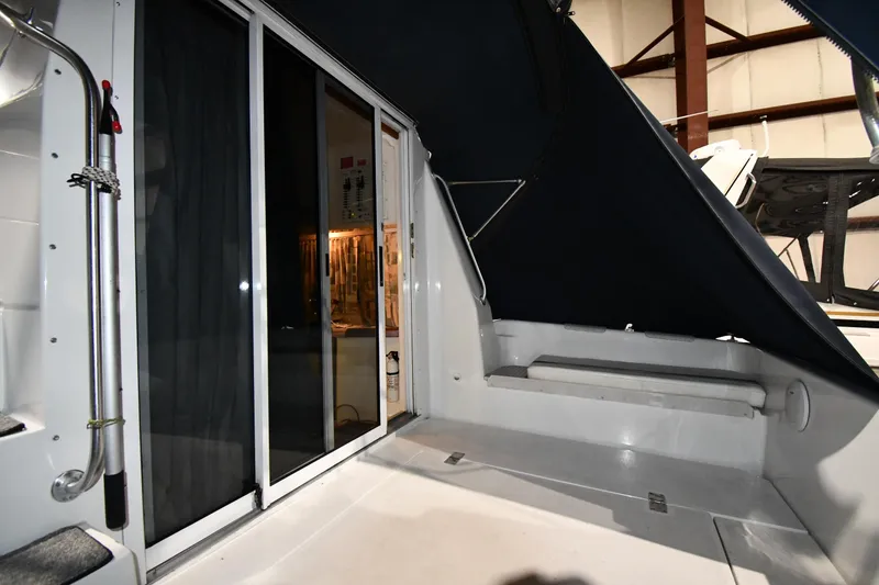 Slide: The Image of 1997 Mainship 40 Sedan Bridge interior with sliding glass doors and seating area. - 7