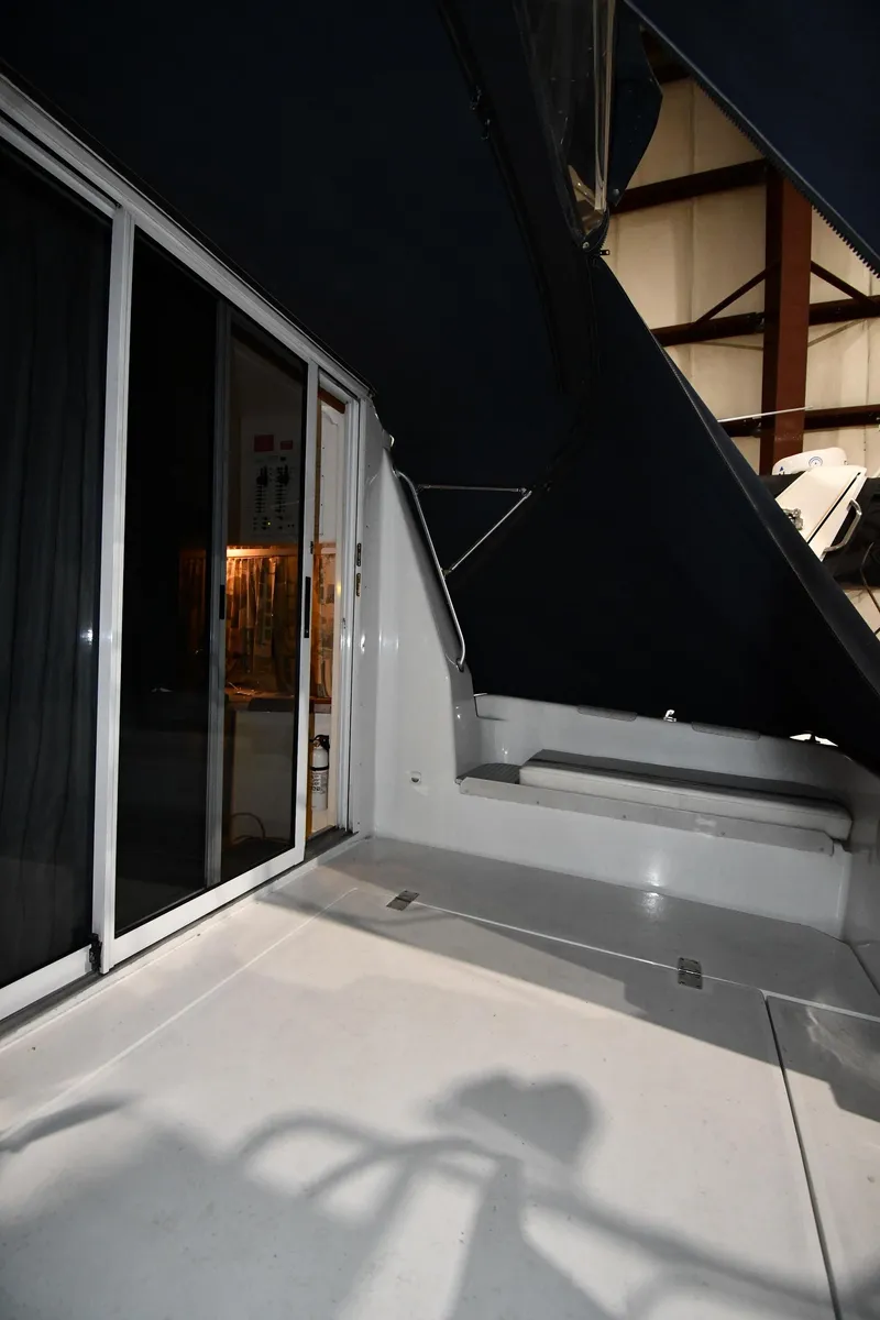 Slide: The Image of 1997 Mainship 40 Sedan Bridge yacht interior with sliding glass doors and seating area. - 8