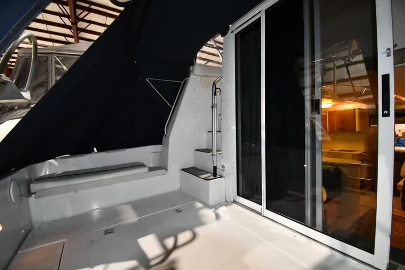 Slide: The Image of 1997 Mainship 40 Sedan Bridge interior with sliding doors and seating area. - 9