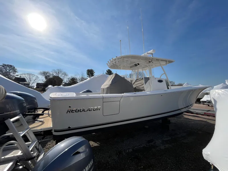 Slide: The Image of 2018 Regulator 31 boat under clear blue sky, parked outdoors. - 1
