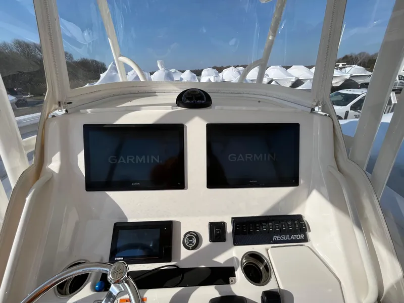 Slide: The Image of 2018 Regulator 31 boat dashboard with dual Garmin displays and control panel. - 13