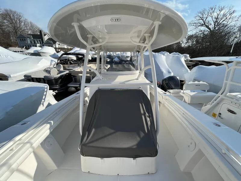 Slide: The Image of 2018 Regulator 31 boat with T-top and seating, docked among other boats. - 16