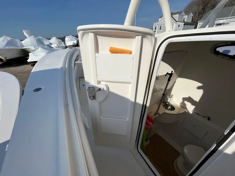 Slide: The Image of 2018 Regulator 31 boat interior with open cabin door, showing compact bathroom amenities. - 20