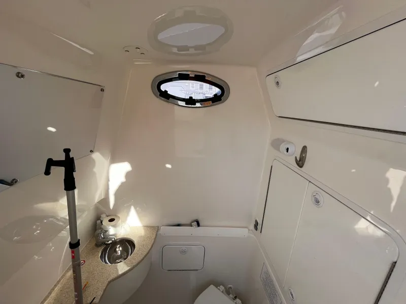 Slide: The Image of 2018 Regulator 31 boat interior with sink, toilet, and storage cabinets. - 23
