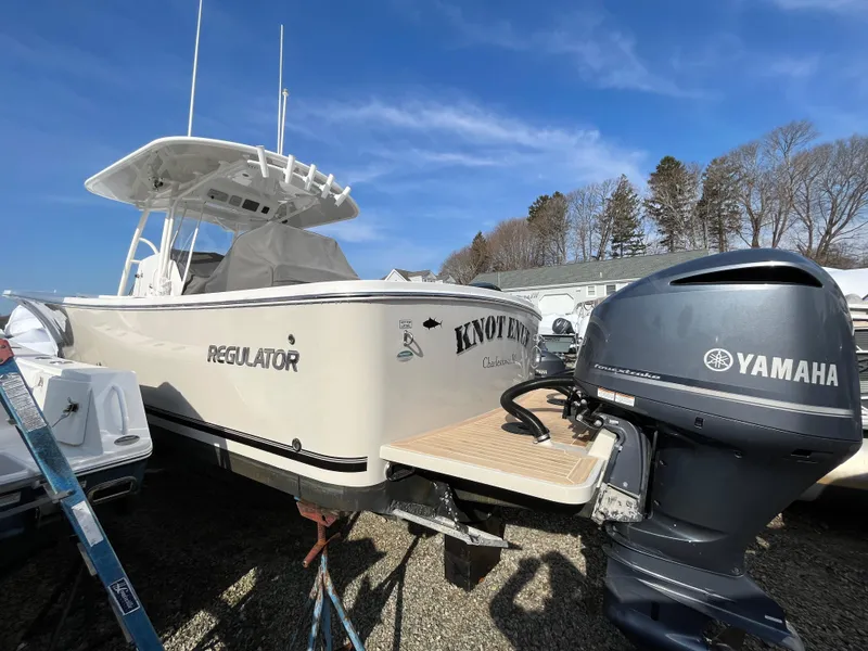 Slide: The Image of 2018 Regulator 31 boat with Yamaha engine, parked outdoors under blue sky. - 3