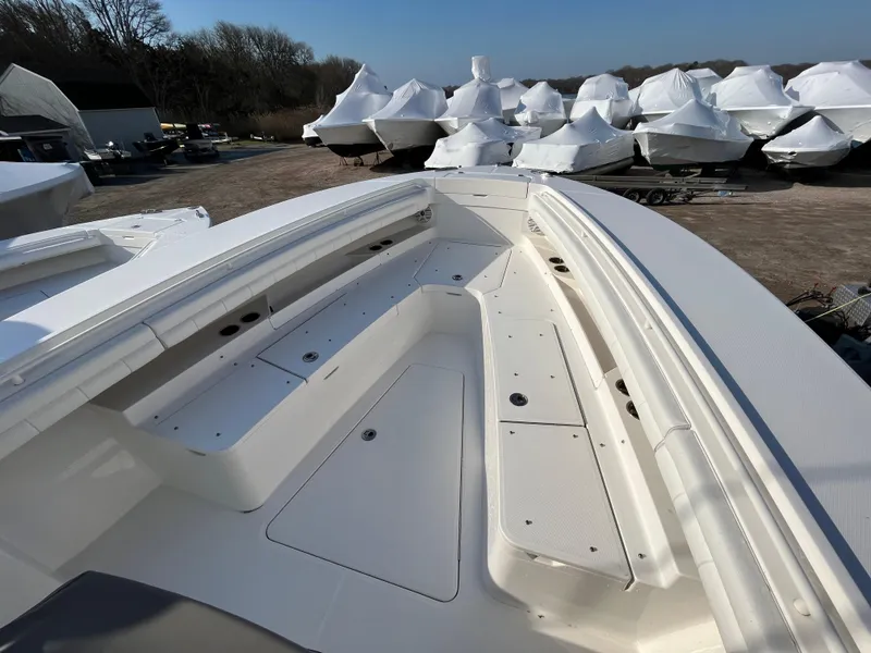 Slide: The Image of 2018 Regulator 31 boat deck with seating, surrounded by covered boats in storage. - 31