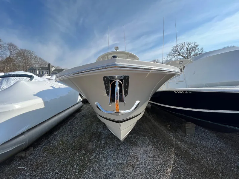 Slide: The Image of 2018 Regulator 31 boat front view, anchored on gravel, with clear blue sky background. - 4