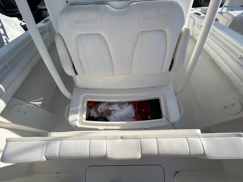 Slide: The Image of 2018 Regulator 31 boat interior with white seating and storage compartment open. - 45