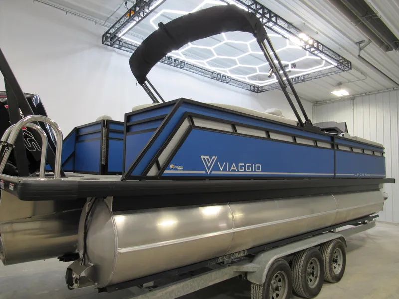 Slide: The Image of 2025 Viaggio X24U pontoon boat in a showroom, featuring a sleek blue design. - 3