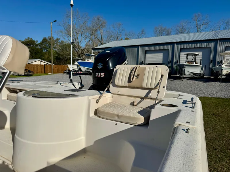 Slide: The Image of 2014 Carolina Skiff 198 DLV boat with 115 HP engine, parked near a metal building. - 9