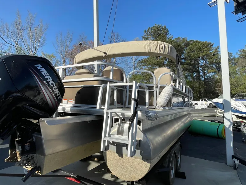 Slide: The Image of 2019 Sun Tracker SportFish 22 DLX pontoon boat with Mercury outboard motor, parked outdoors. - 20