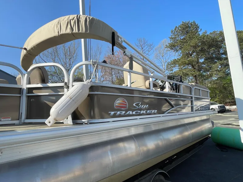 Slide: The Image of 2019 Sun Tracker SportFish 22 DLX pontoon boat with canopy, docked outdoors. - 21
