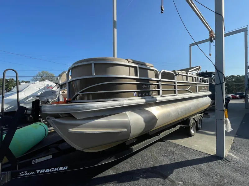 Slide: The Image of 2019 Sun Tracker SportFish 22 DLX pontoon boat on trailer under blue sky. - 24