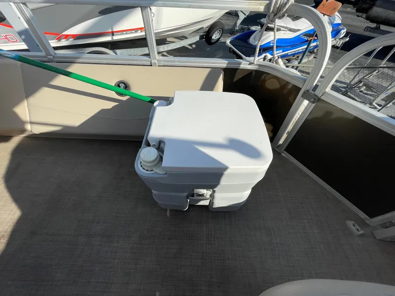Slide: The Image of 2019 Sun Tracker SportFish 22 DLX boat interior with portable toilet on deck. - 30