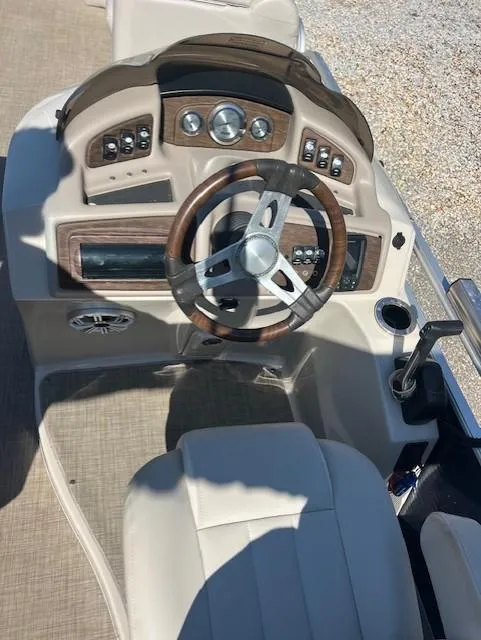 Slide: The Image of 2015 Bennington 2574 GCW boat dashboard with steering wheel and control panel. - 11