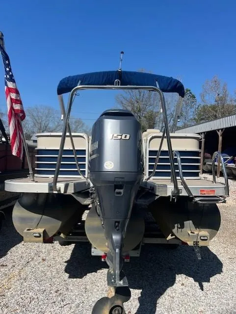 Slide: The Image of 2015 Bennington 2574 GCW pontoon boat with Yamaha 150 engine, parked on gravel. - 3