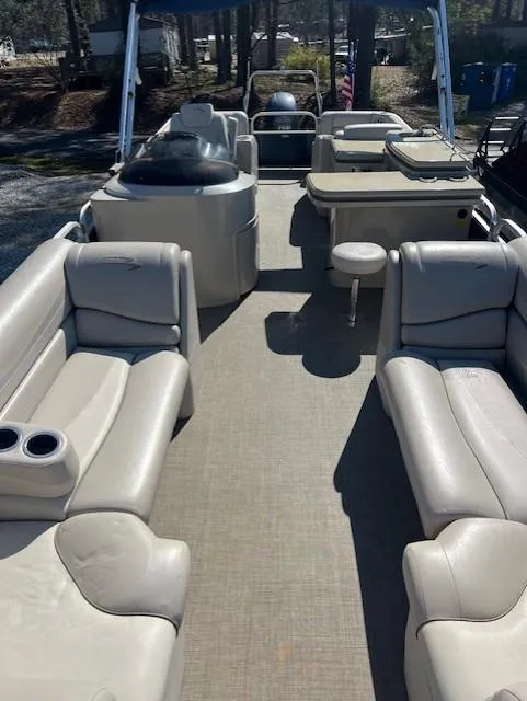 Slide: The Image of 2015 Bennington 2574 GCW pontoon boat interior with beige seating and spacious layout. - 6