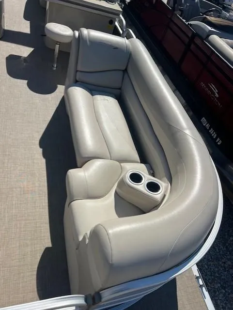 Slide: The Image of 2015 Bennington 2574 GCW pontoon boat with beige seating and cup holders. - 7