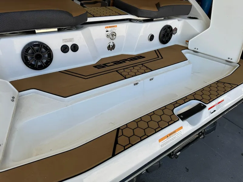 Slide: The Image of 2021 Scarab 215 ID boat interior with speakers and honeycomb-patterned flooring. - 13