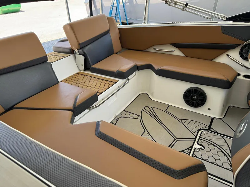 Slide: The Image of 2021 Scarab 215 ID boat interior with brown and gray seating, stylish flooring, and speaker system. - 6