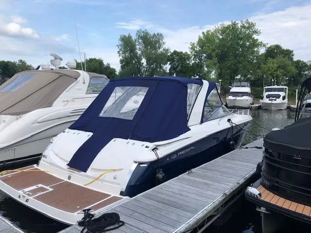 Slide: The Image of 2011 Regal 3350 Cuddy boat docked with blue canopy, surrounded by other boats. - 10