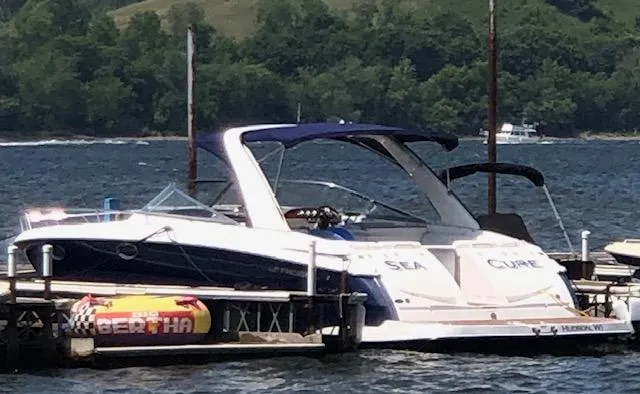 Slide: The Image of 2011 Regal 3350 Cuddy boat docked on a lake with scenic background. - 11