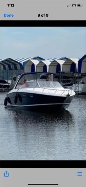Slide: The Image of 2011 Regal 3350 Cuddy boat docked near covered marina slips. - 12