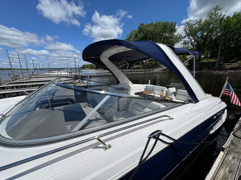 Slide: The Image of 2011 Regal 3350 Cuddy boat docked under blue sky with American flag. - 14