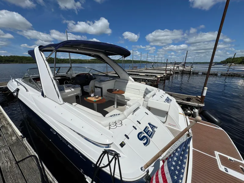 Slide: The Image of 2011 Regal 3350 Cuddy boat docked, featuring spacious seating and American flag. - 15