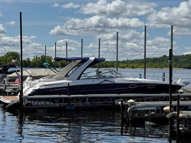 Slide: The Image of 2011 Regal 3350 Cuddy boat docked on a sunny day with cloudy sky. - 2