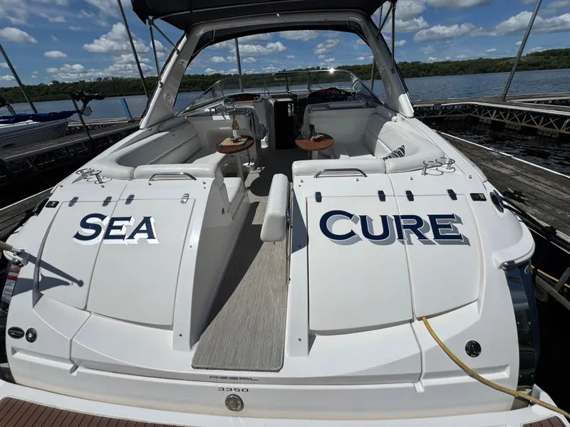 Slide: The Image of 2011 Regal 3350 Cuddy boat docked, featuring "Sea Cure" name on the stern. - 20