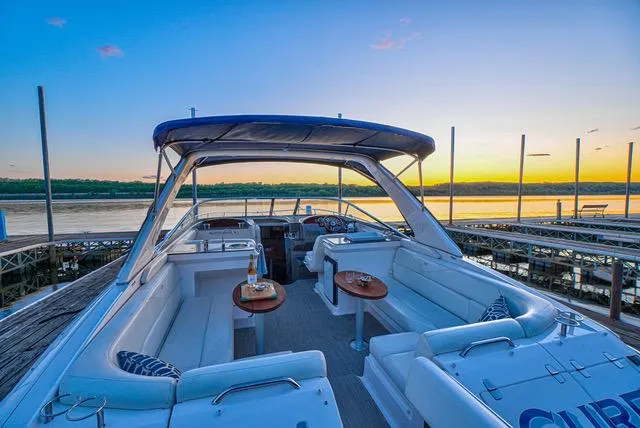 Slide: The Image of 2011 Regal 3350 Cuddy boat interior at sunset, featuring comfortable seating and scenic waterfront views. - 21