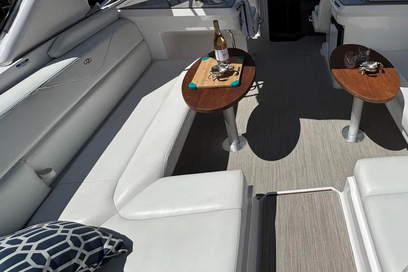 Slide: The Image of Luxurious 2011 Regal 3350 Cuddy boat interior with white seating and wooden tables. - 23