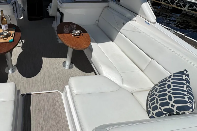 Slide: The Image of Luxurious 2011 Regal 3350 Cuddy boat interior with white seating and wooden tables. - 25
