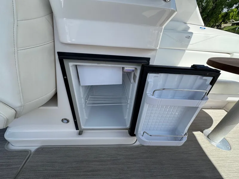Slide: The Image of Open mini fridge on 2011 Regal 3350 Cuddy boat, showing interior shelves and door storage. - 29